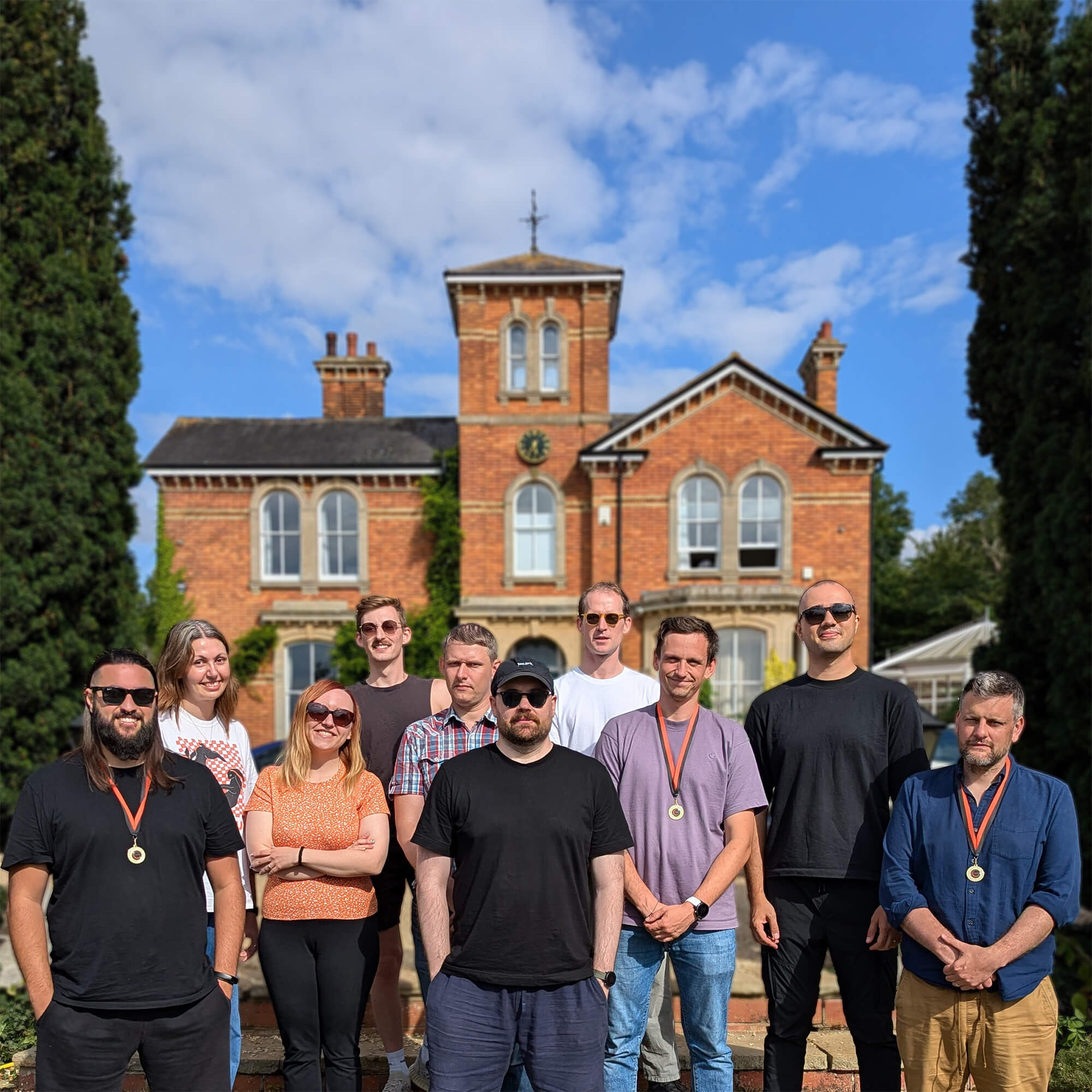 The Opalescent team in front of a big, lovely house